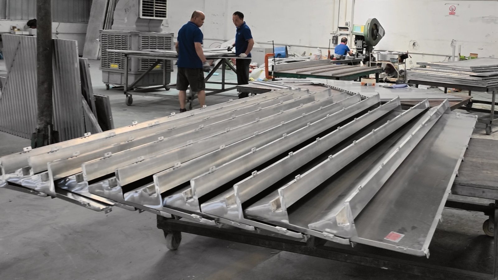 LINDELACR L-return aluminum trays with mounting tabs staged for crate order after the shop-drawing check
