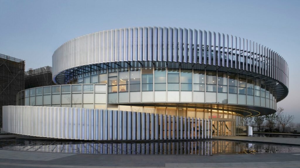 LINDELACR solid aluminum facade fins on a landmark circular building at dusk