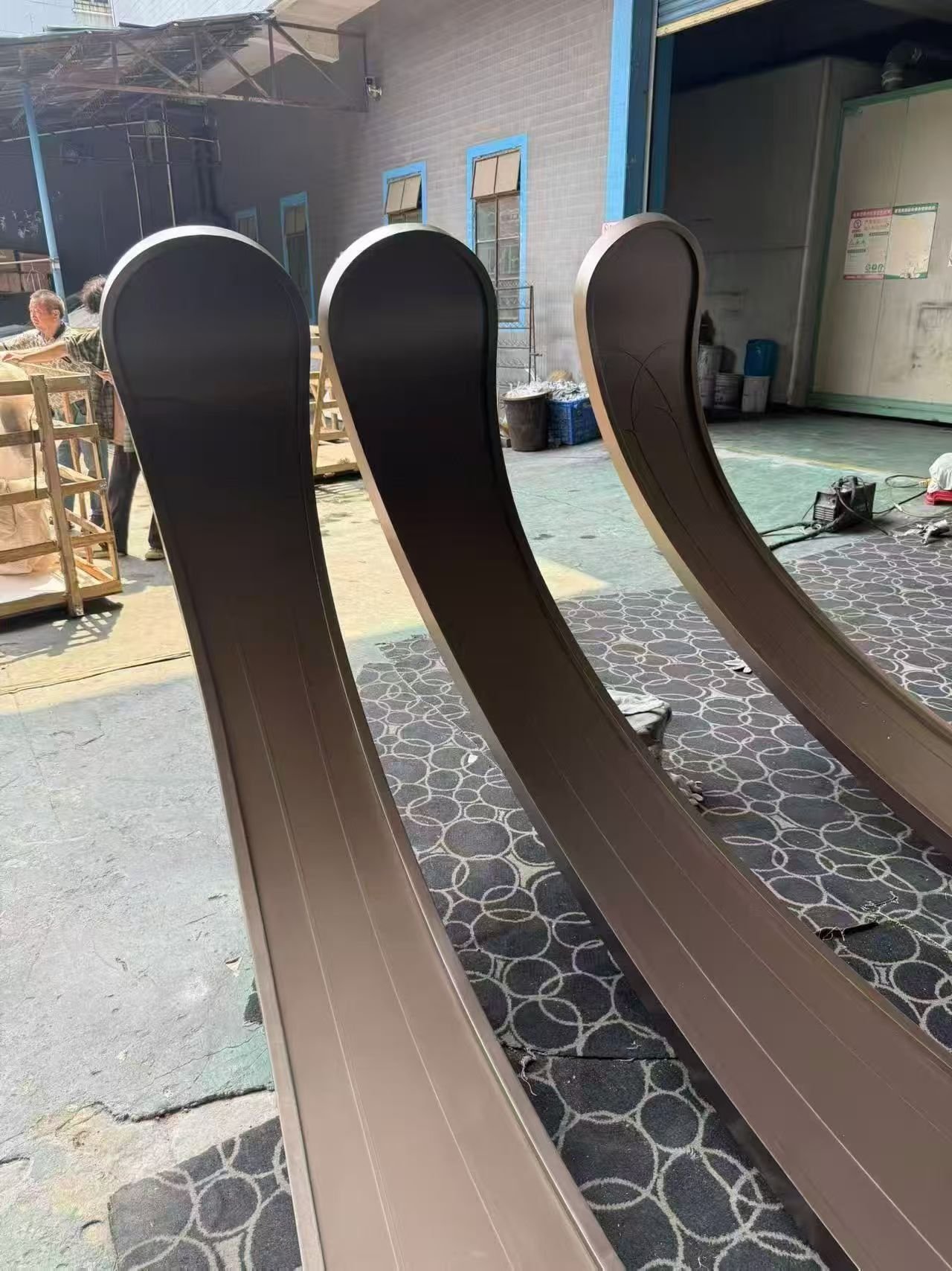 LINDELACR Foshan yard: bronze custom column-cover petals standing on protective mats before crate packing