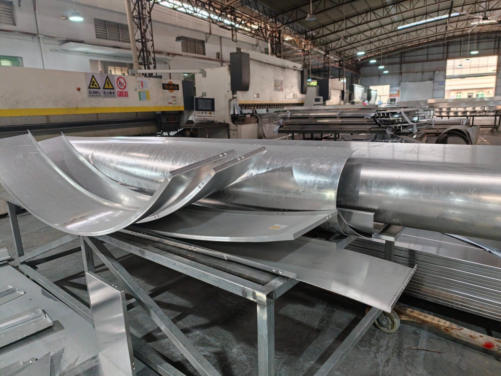 LINDELACR Foshan: mill-finish curved aluminum trays staged in front of a Durma press brake