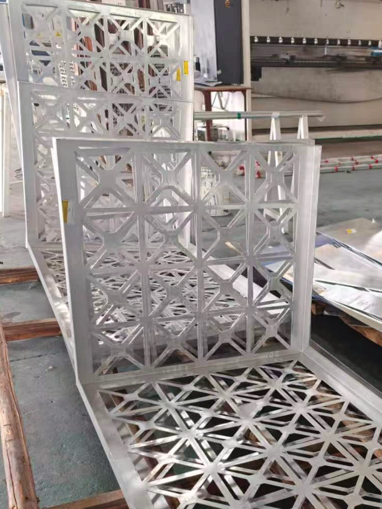 LINDELACR Foshan shop: white powder-coated aluminum ceiling frames with geometric CNC cut-outs standing beside a press brake