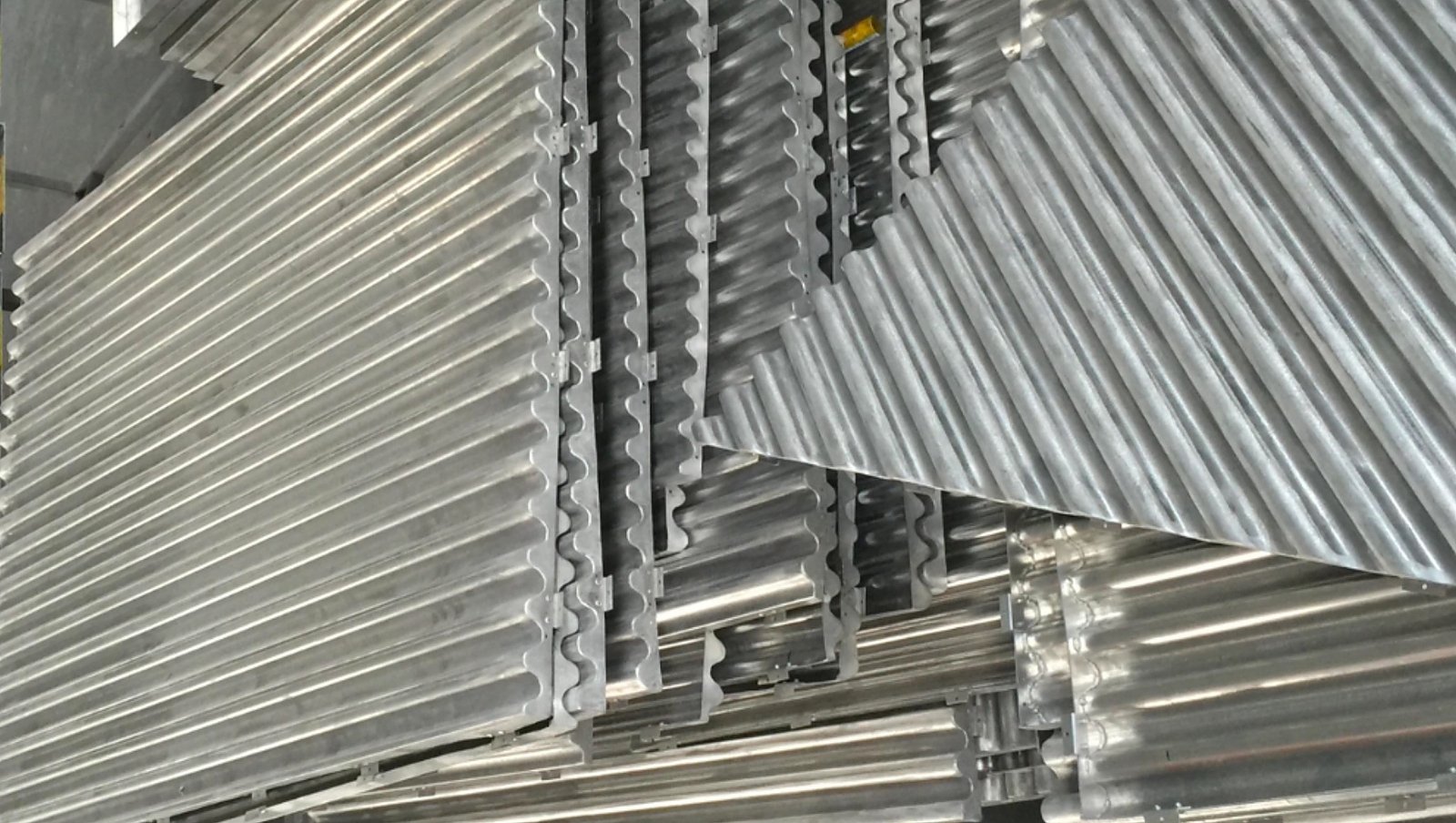Close-up of mill-finish corrugated aluminum veneer ribs and returns at LINDELACR Foshan before PVDF or powder coating