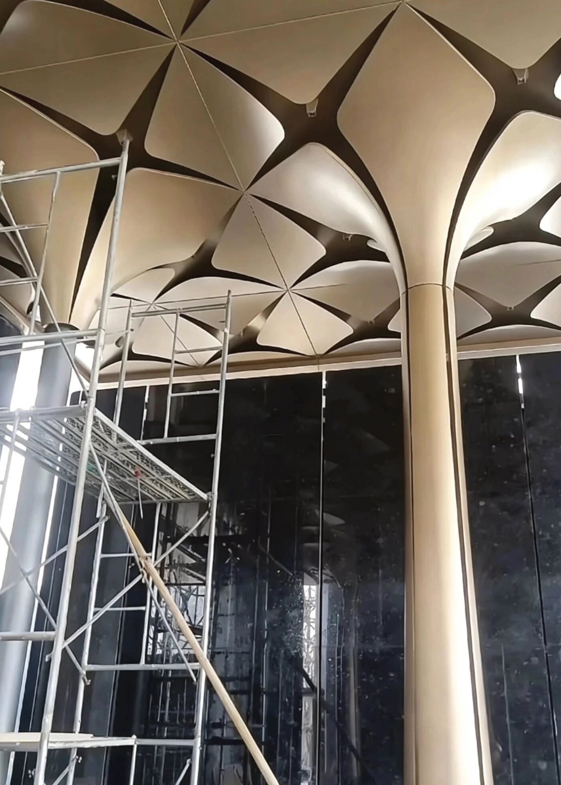 Scaffold beside gold 3D petal ceiling and flared column cover during install at Thailand Golden Bay