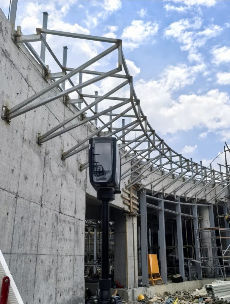 LINDELACR site survey: terrestrial laser scanner in front of a curved steel facade subframe anchored to concrete