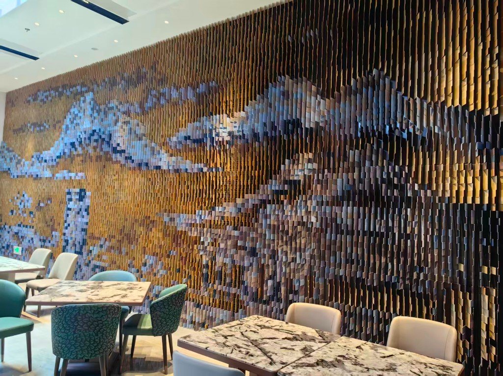 Unnamed dining room. Many single aluminum blades in several colors form a picture on the wall